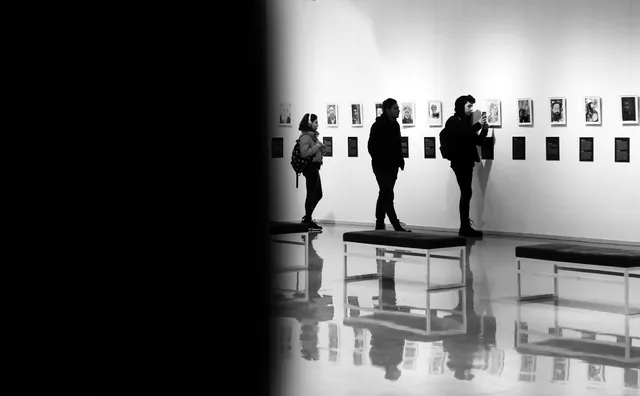 Visitors looking at artwork on a gallery wall.
