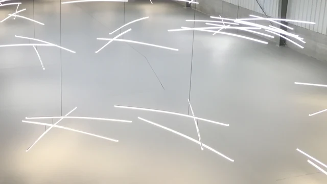 Suspended white light bars forming a sculptural installation.