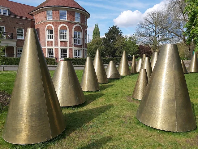 Golden textured cones in a public interactive sculpture garden.