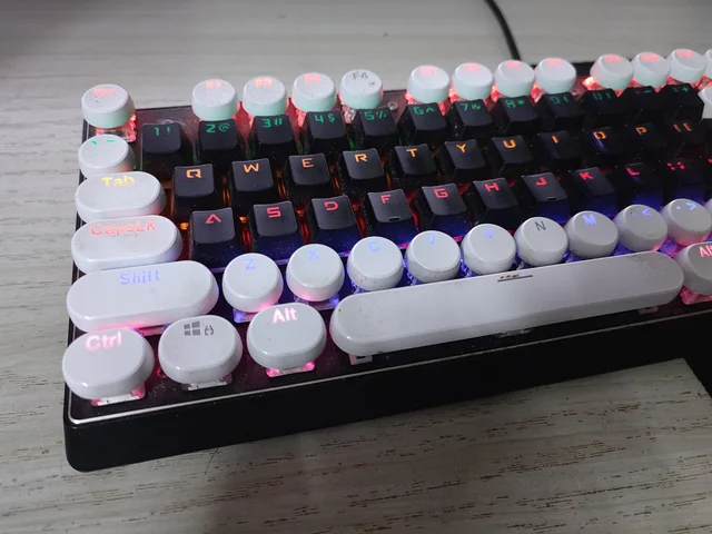 A customised black-and-white mechanical keyboard with illuminated keys.