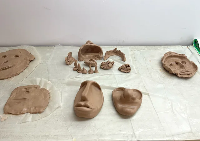 Representative display of hand-modelled clay sculptures, masks and faces; not the Clay Vocabulary exhibition.