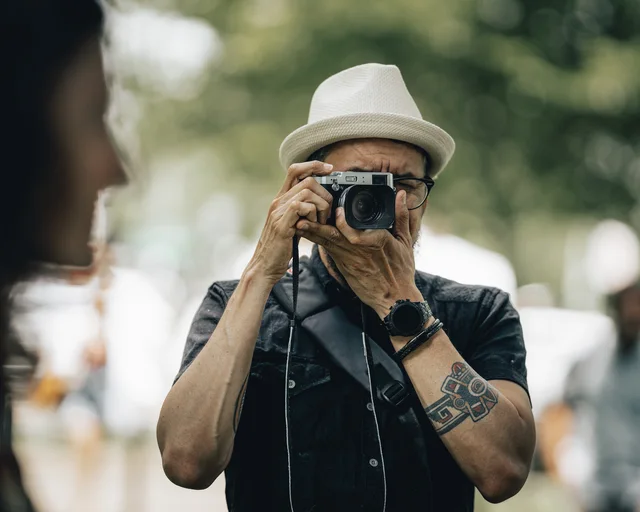 A street photographer looking through a camera during a photowalk.
