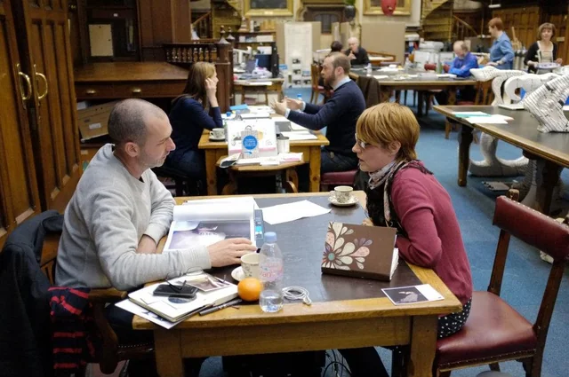 Representative photography portfolio review with people discussing prints across tables