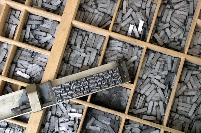 Movable metal letterforms arranged in a traditional type case.