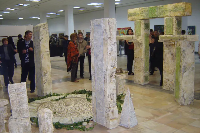 Visitors walking between a sculptural installation.