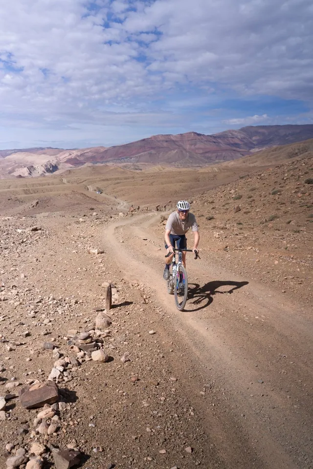 Cyclist riding through dry rocky terrain; representative cycling photo
