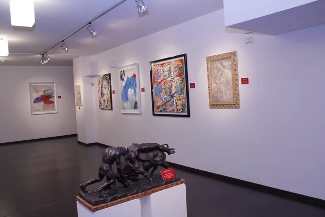 Paintings and sculpture displayed in a contemporary art gallery.
