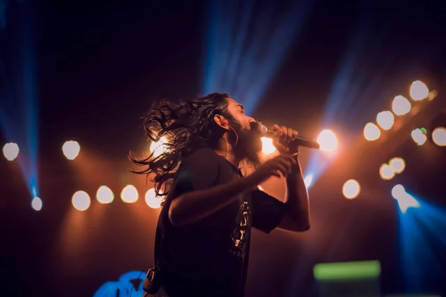 A singer performing under stage lighting; representative activity photo, not the advertised venue or participants.